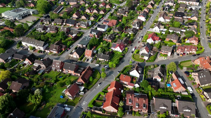 Aerial flyover small american village at sunny day. Cars on street. Top down shot. Green trees at sunset in summer. Calm and peaceful city on United States.