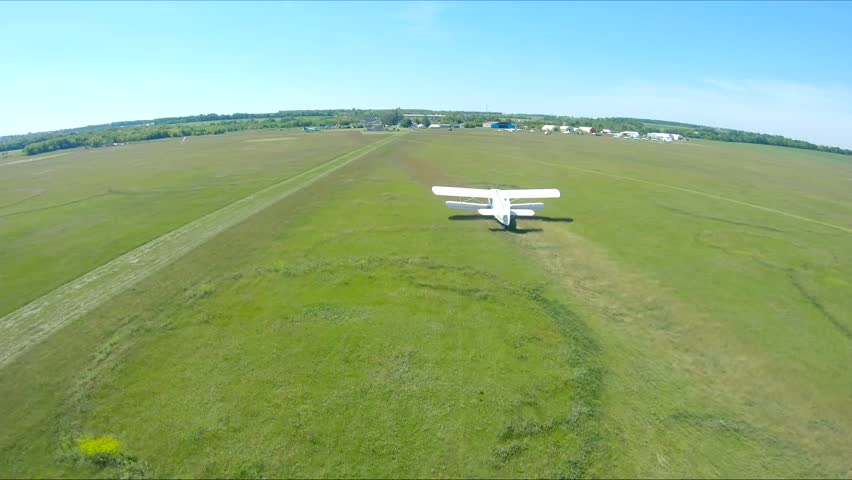 Airplane riding along rural runway before the take-off. Old aircraft heading towards airstrip for before flight at airfield. Retro plane preparing to fly. Aviation concept. Aerial shot from drone - Powered by Shutterstock - Get 15% off with code: PIKWIZARD15
