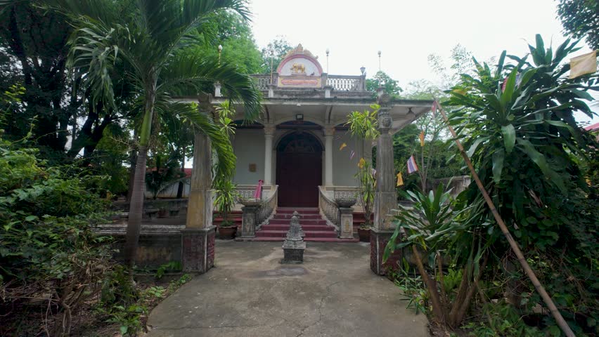 Serene footage of an aged temple, nestled amidst vibrant tropical foliage.  Ideal for travel, history, spirituality, and nature documentaries.  Mysterious and atmospheric.