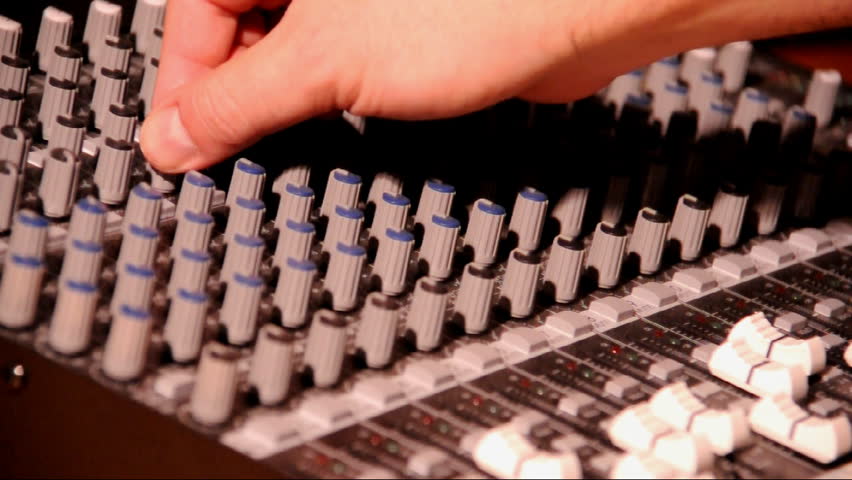 Adjusting the levels on an audio mixer.