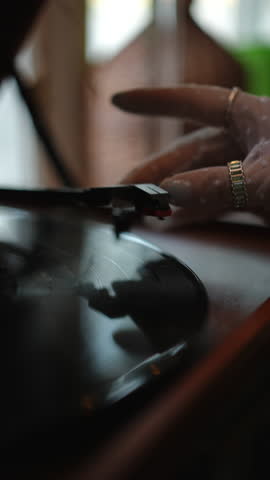 A beautifully detailed closeup shot of a hand gently placing the needle onto a vintage vinyl record