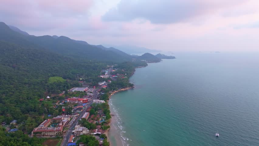 White Sand Beach glows at sunset with tourists along the water,Koh Chang