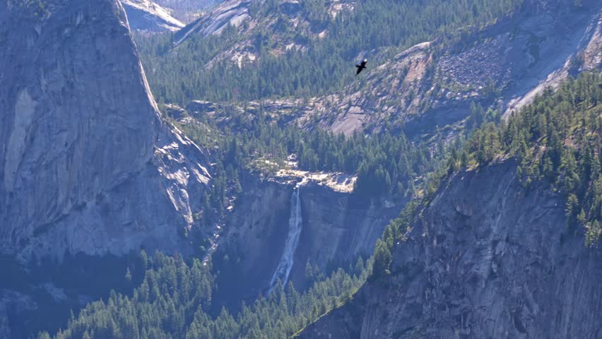 Footage capturing the majestic Nevada Falls waterfall from the elevated vantage point of Glacier Point in Yosemite National Park, California.