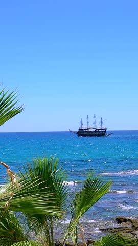 A ship surfing the blue sea. A summer time magical landscape of a ship in the blue sea. Fresh green palm trees dancing with the fresh wind. Suitable for trips and tourism concept designs.
