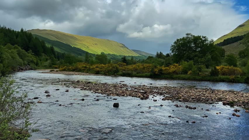 Panoramic View Of River, Mountain, And Green Forest In Highlands Of Scotland. - wide pan shot