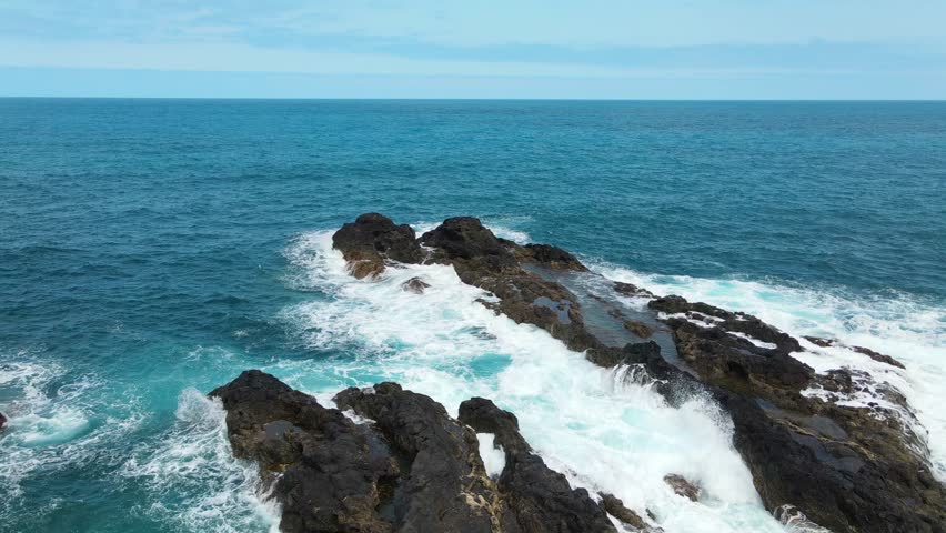 waves crashing on rocks, drone shot, fast motion, seascape background, impressive nature of Madeira island, Portugal