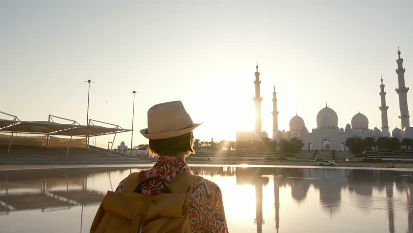 female tourist enjoys serene moment while admiring stunning view of the Sheikh Zayed Mosque in Abu Dhabi. grand architecture and peaceful surroundings, view from park Wahat Al Karama