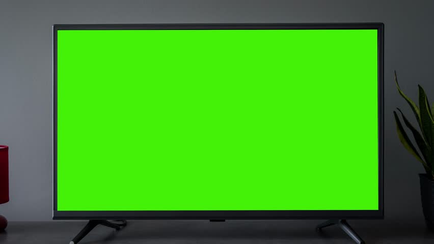 TV screen mockup background. Lcd tv monitor with blank green screen in living room while watching 
