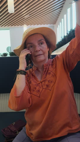 Woman in a stylish environment conversing on a smartphone, gesturing expressively and listening attentively, showcasing modern urban lifestyle in Madrid