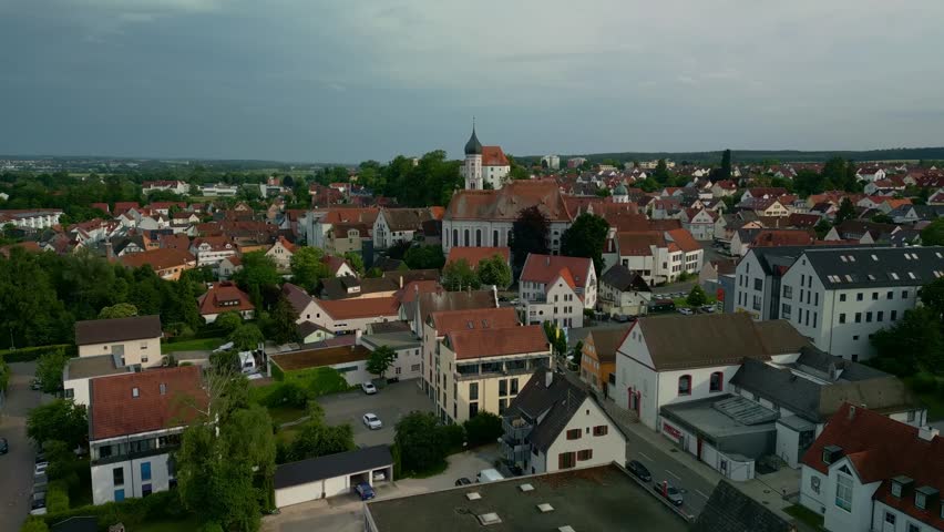 An Aerial view of Burgau in Gunzburg district, showing red-roofed buildings, a church, and green landscapes, Germany