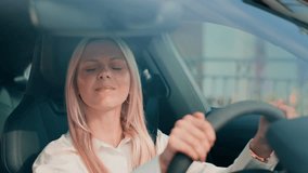 Overwhelmed blonde woman leaning forward with arms crossed on steering wheel. Hiding face while processing strong emotions. Experiencing stress or fatigue during difficult moment inside vehicle. - Powered by Shutterstock - Get 15% off with code: PIKWIZARD15