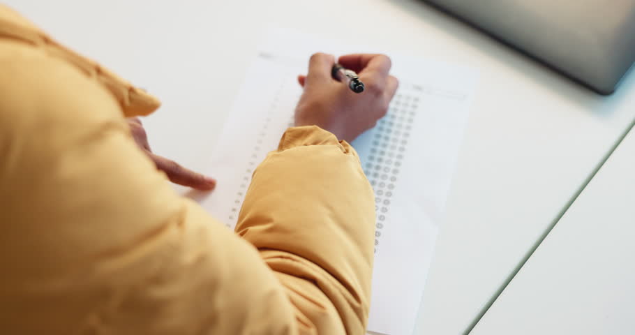Hands, person and student writing exams in classroom for answer, test and assessment. Above, learner and information for college quiz, question paper and multiple choice for learning at university