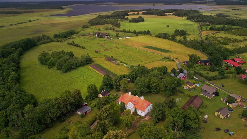 Aerial views highlight Saare Manor nestled in the heart of Noarootsi, where neat lawns, dense tree borders, and natural greenery frame the historic building in a timeless rural setting.