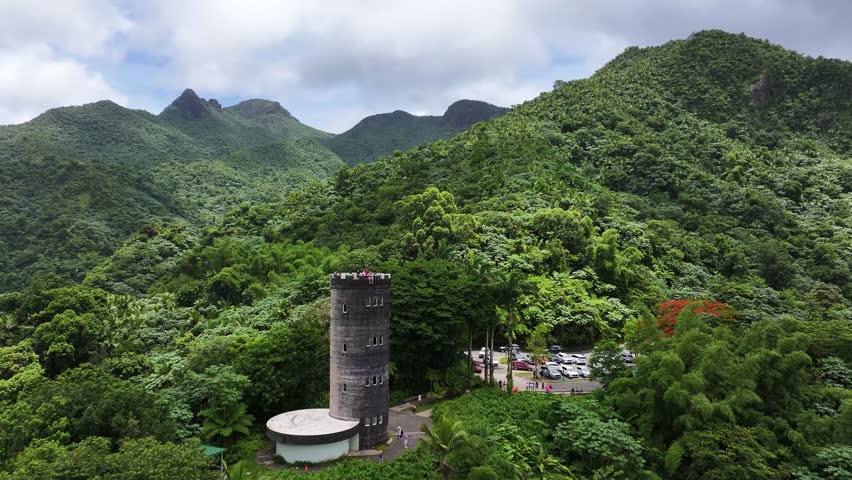 Cinematic drone footage showcasing the iconic observatory tower rising above an endless sea of lush green forest in El Yunque Rainforest, Puerto Rico