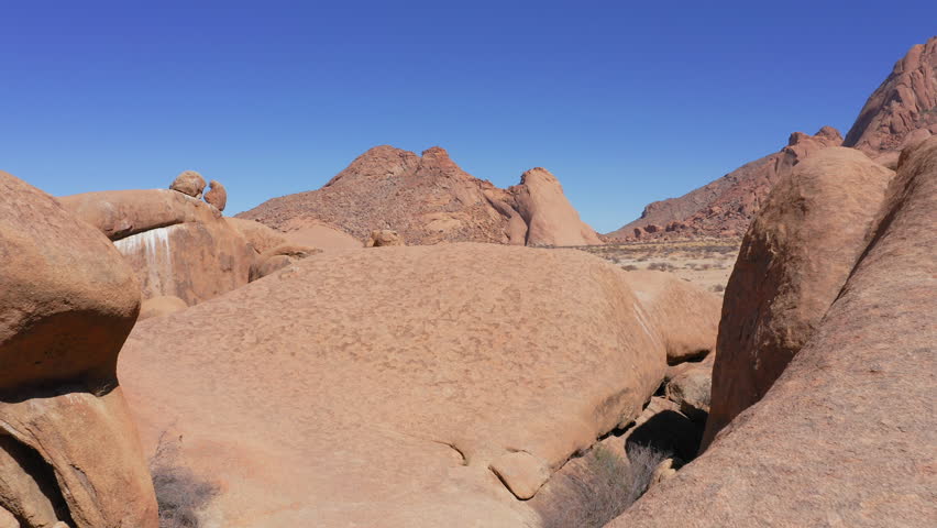Aerial view of hiker under Spitzkoppe natural arch, Namibia, African Adventure Travel