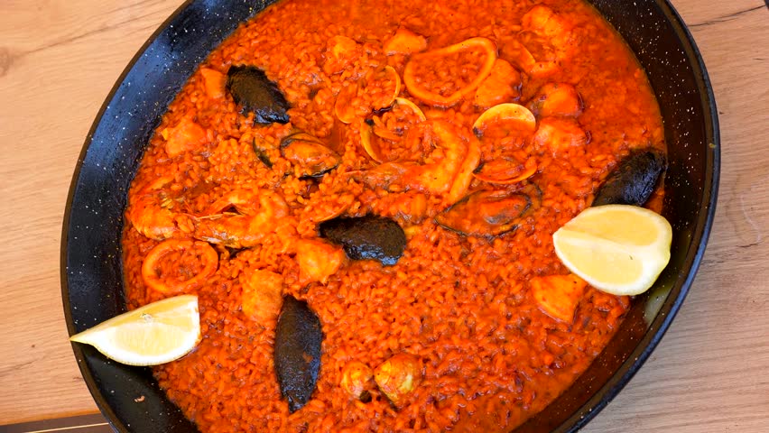 Seafood paella presenting vibrant mediterranean ingredients, featuring succulent shellfish resting on traditional spanish pan with golden hued rice and aromatic spices