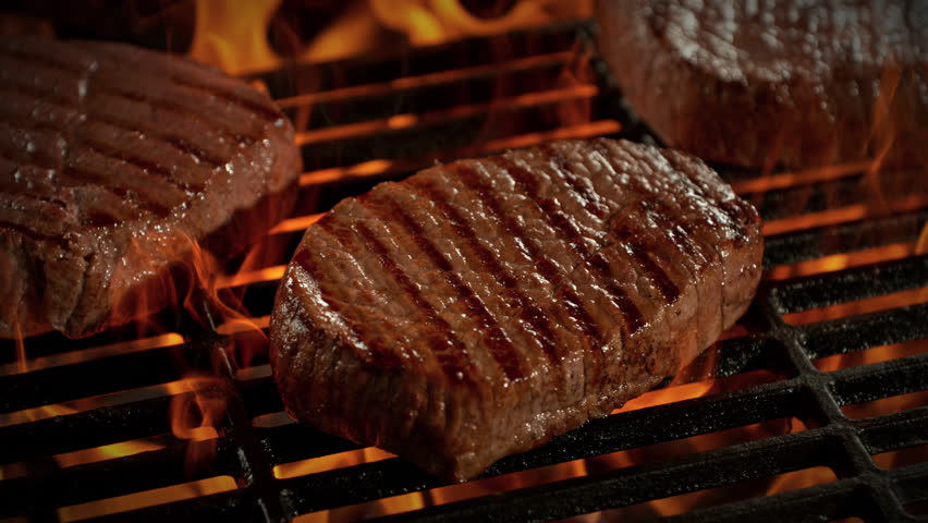 Super Slow Motion Shot of Beef Steak Meat on Fired Up Grill with Camera Motion at 1000fps.