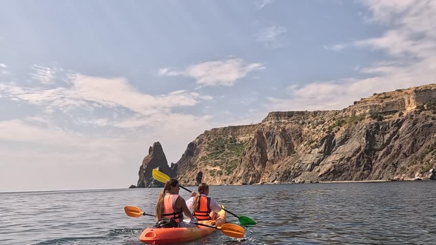 Kayaking Crimea Couple Sea Coast - Two people kayak near a rocky cliff in the sea.