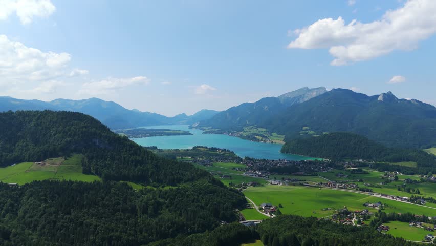 Aerial: Lake Wolfgang and Strobl am Wolfgangsee in the Salzburg Alps region at midday in Austria, orbit drone shot
