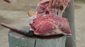 Street vendor cutting fresh pork meat outdoors