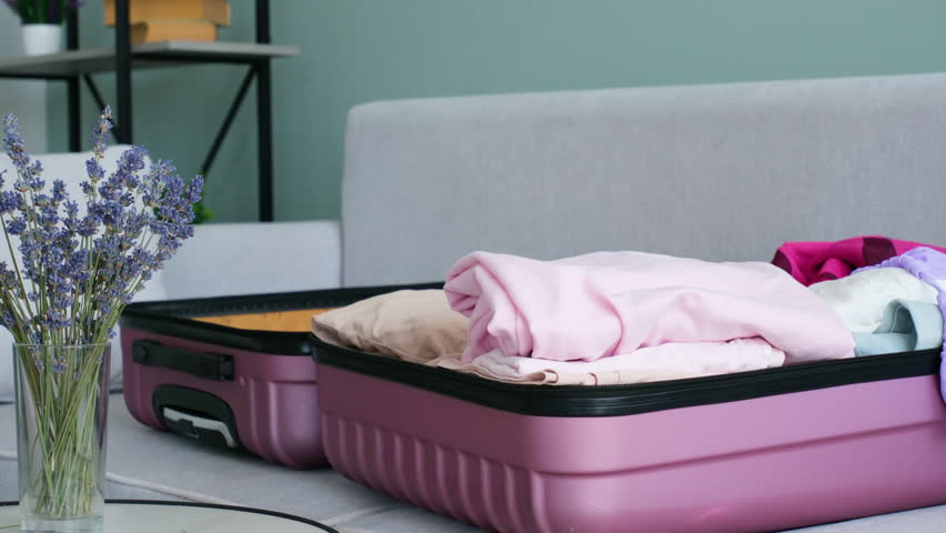 A woman puts pills in a suitcase. Concept of medication required in journey