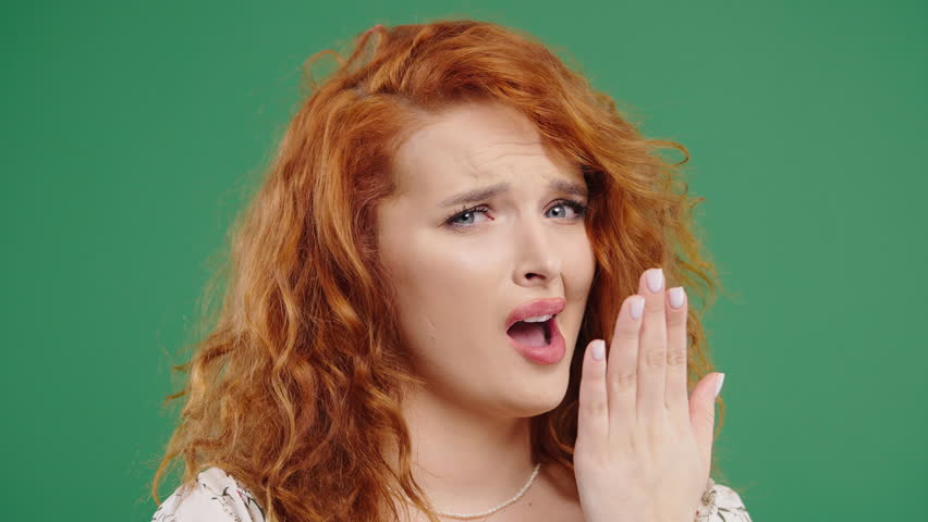 Bored red-haired woman pretending to yawn and roll eyes during awkward situation