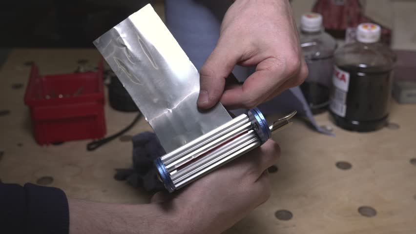 the worker laser cuts out parts of wood, makes a roof from an aluminum can, paints and patinas the future walls, glues everything together into one structure and the result is a miniature farmhouse