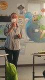 Female Teacher Educating Smart Kids During Science Lesson in Classroom. Primary School Boy Presenting Green Energy Sources in Front of Class Using Earth Model. STEM Education. Dolly Shot Vertical Shot - Powered by Shutterstock - Get 15% off with code: PIKWIZARD15