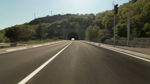 Driving car on coastal road through the tunnel