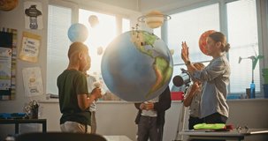Renewable Energy STEM Class: Elementary School Students Attaching Miniature Models of Clouds to Globe. Female Teacher Explaining Science and Energy Sources to Smart Diverse Kids in Modern Classroom. - Powered by Shutterstock - Get 15% off with code: PIKWIZARD15