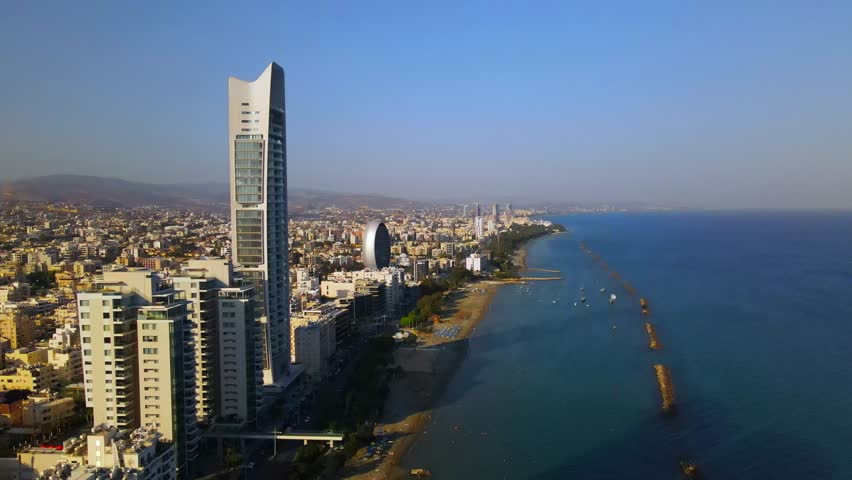 View from above on Limassol buildings, evening Cyprus. 
High-rise towers of Cyprus. Summer sunset and Mediterranean sea with city traffic in the background.