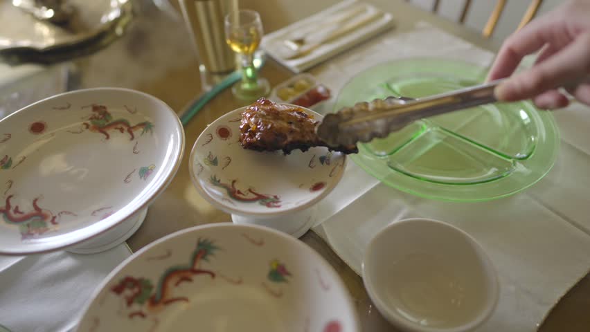 Close-up of chicken drumsticks being served on vintage plates at a beautifully set dining table. Elegant, nostalgic, and perfect for food or lifestyle content.