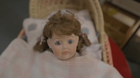 Panning shot of a vintage doll with striking blue eyes tucked inside an old-fashioned baby carriage. Nostalgic, eerie, and cinematic. - Powered by Shutterstock - Get 15% off with code: PIKWIZARD15