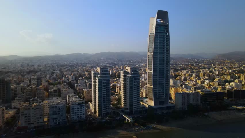 View from above on Limassol buildings, evening Cyprus. 
High-rise towers of Cyprus. Summer sunset and Mediterranean sea with city traffic in the background.