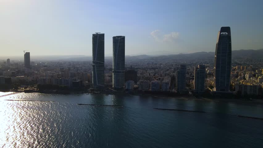 View from above on Limassol buildings, evening Cyprus. 
High-rise towers of Cyprus. Summer sunset and Mediterranean sea with city traffic in the background.