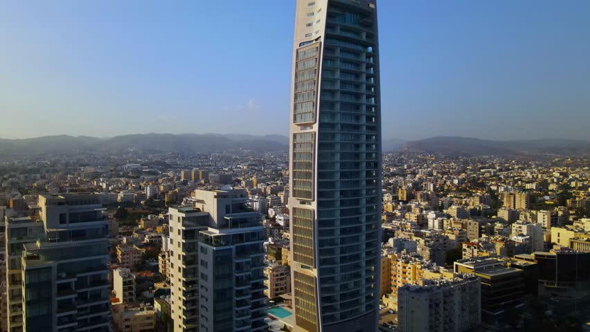 View from above on Limassol buildings, evening Cyprus. 
High-rise towers of Cyprus. Summer sunset and Mediterranean sea with city traffic in the background.