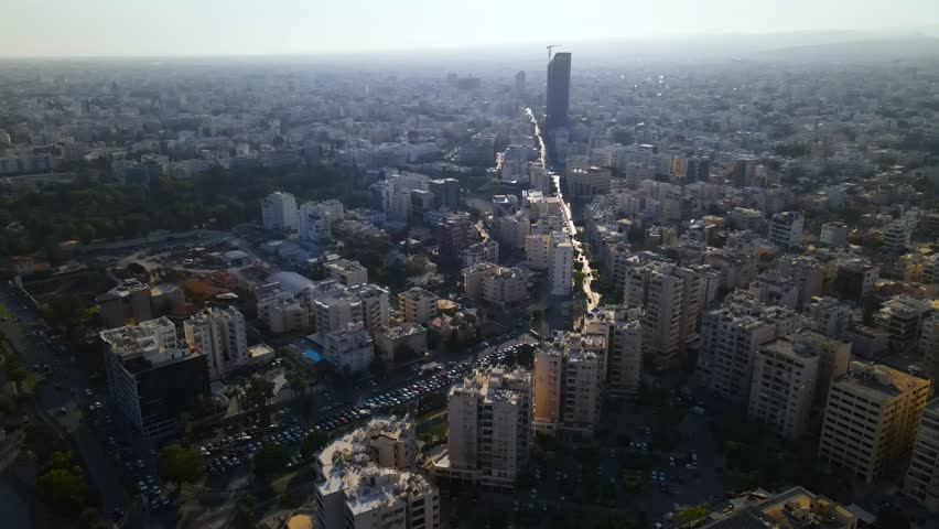 View from above on Limassol buildings, evening Cyprus. 
High-rise towers of Cyprus. Summer sunset and Mediterranean sea with city traffic in the background.