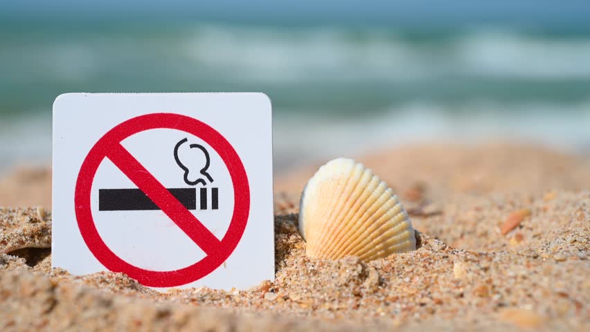 No Smoking sign. Smoking is prohibited in public places. Prohibitory sign against the background of sand and sea, ocean. Attention, smoking is prohibited.