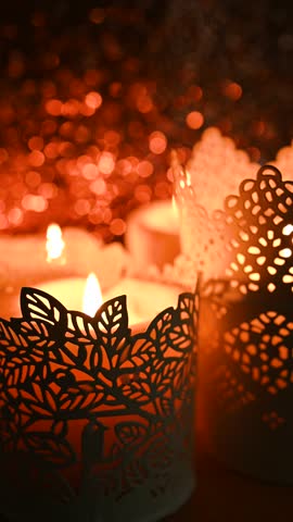 Interior decor, festive coziness, stock video. Burning candles in decorative candlesticks against sparkling bokeh background, selective focus,	