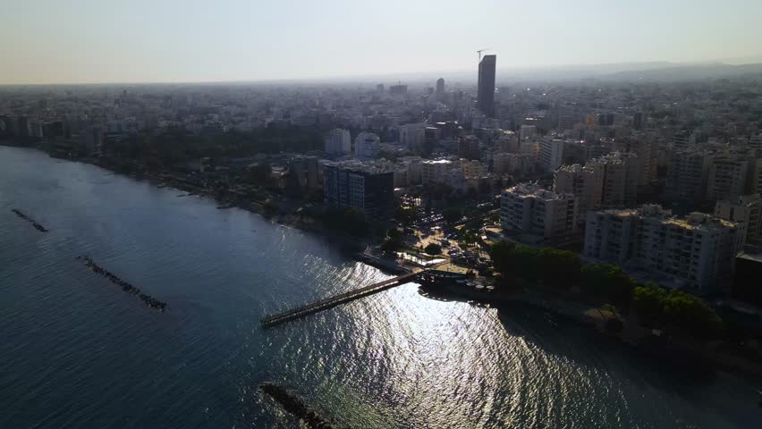View from above on Limassol buildings, evening Cyprus. 
High-rise towers of Cyprus. Summer sunset and Mediterranean sea with city traffic in the background.