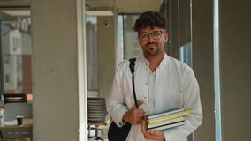 Confident medical student carrying books in university corridor - Powered by Shutterstock - Get 15% off with code: PIKWIZARD15