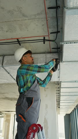 Electrician installing cables on a construction site