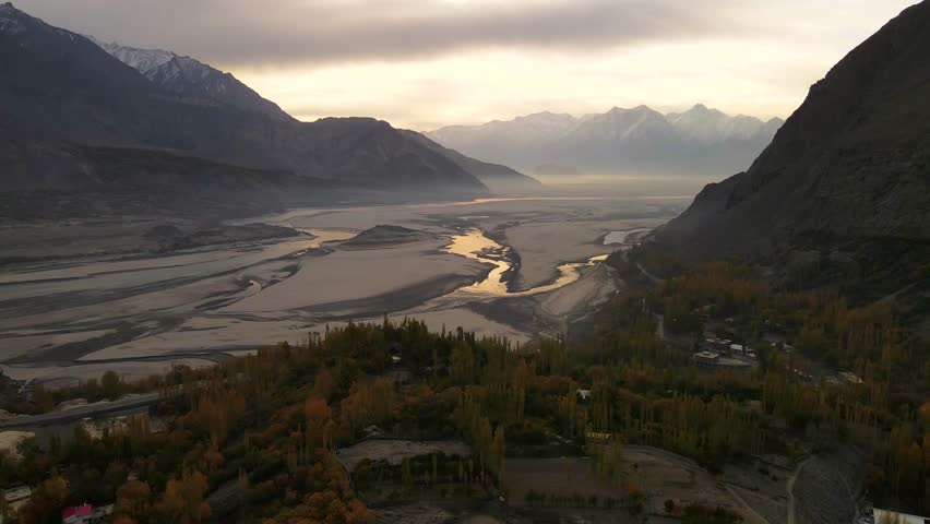Aerial view of Indus River and mountains under dramatic sky, Pakistan.