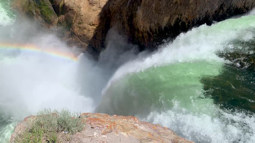 Yellowstone National Park Brink of the Lower Falls rainbow. Cliff edge view of powerful waterfall