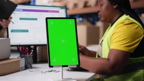 Employee reviews copy space monitor in the storage room for data entry, inventory tracking mockups and visuals or barcode printer interfaces. Distribution hub staff manages cargo. Camera B. - Powered by Shutterstock - Get 15% off with code: PIKWIZARD15