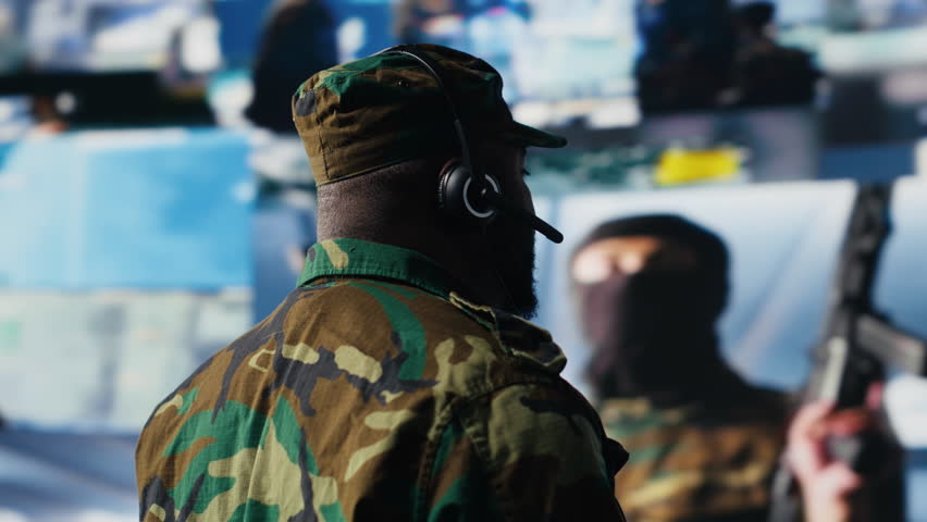 Black soldier guiding troops with satellite coordinates to create tactics, high tech control center for a mission. Soldier transmitting threat detection insight for national safety. Camera B.