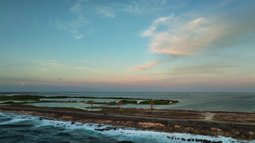 Aerial view of serene island with windmill at sunset, Netherlands.