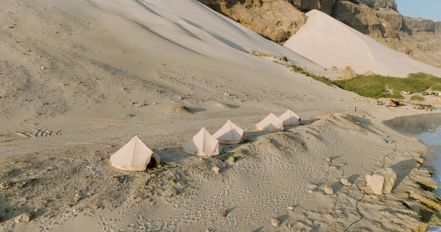 Aerial view of sand dunes and tents by beach, Yemen.