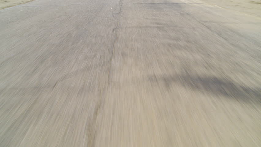 Palm Springs POV pan up from the road driving down the rugged San Jacinto Mountains in the distance in California under a clear blue sky on a bright, sunny day.
