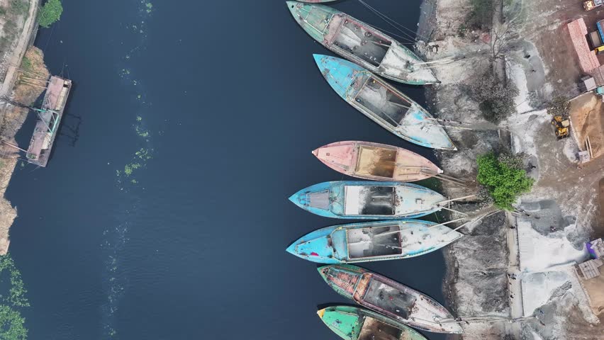 Aerial view of factory and boats by river, Bangladesh.
